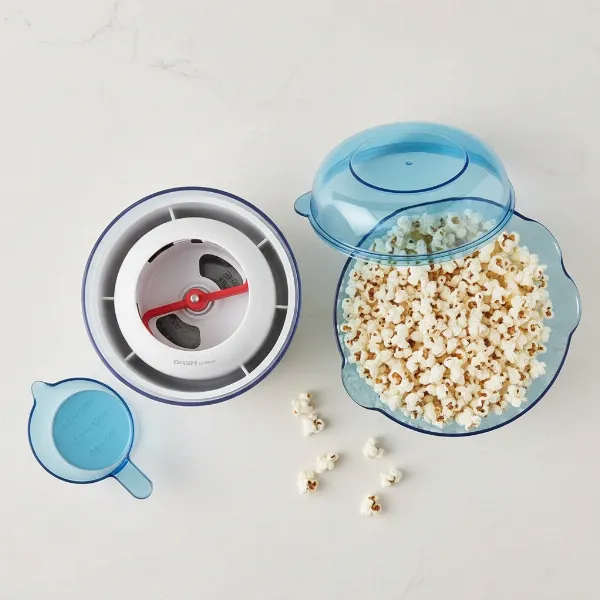Dash SmartStore popcorn maker with base nesting in bowl, lid as serving bowl and measuring cups.